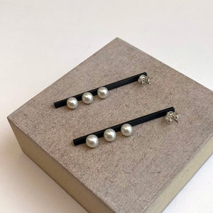 Vertical suspended pearl earrings in oxidised sterling silver by Melanie Katsalidis